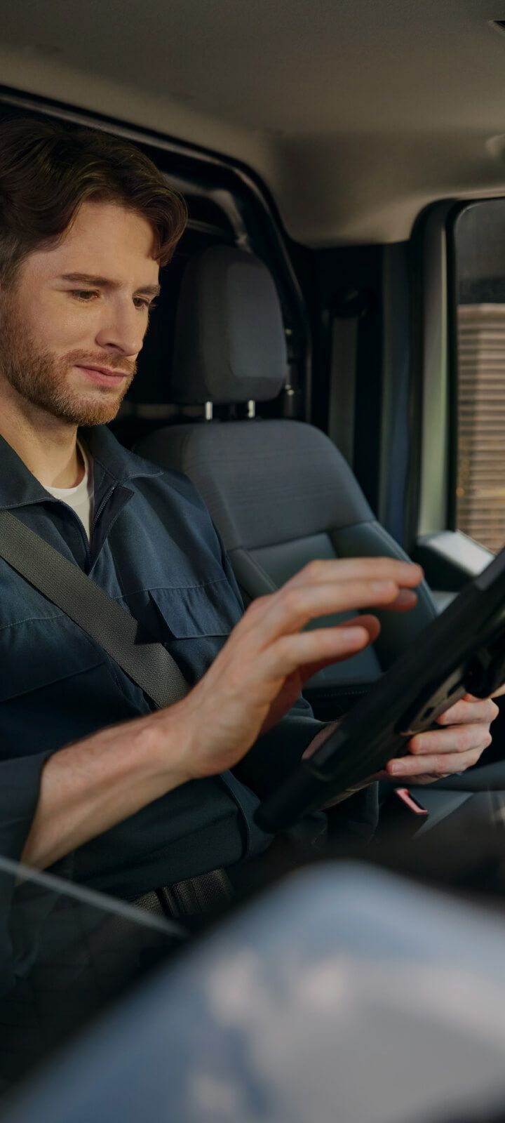 Mann bedient den Touchscreen des Infotainmentsystems in einem Fahrzeug.